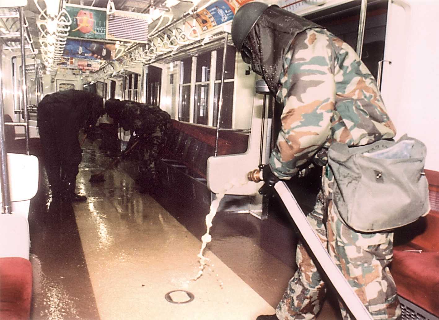 Photo of a soldier in prodective gear cleaning the Tokyo subway.
