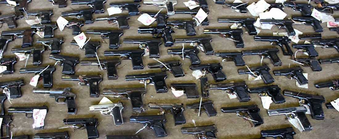 A photo of numerous pistols on the ground.
