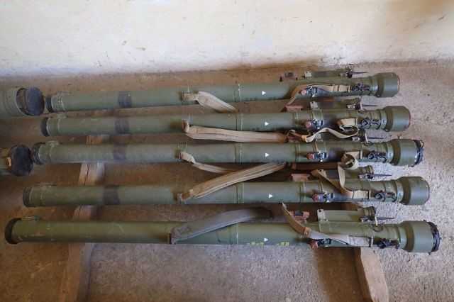 A closeup photo of five manpads on the ground.