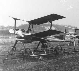 Black and white photo of a double-decker drone with a propeller at the front. The drone is standing on the ground on rails.