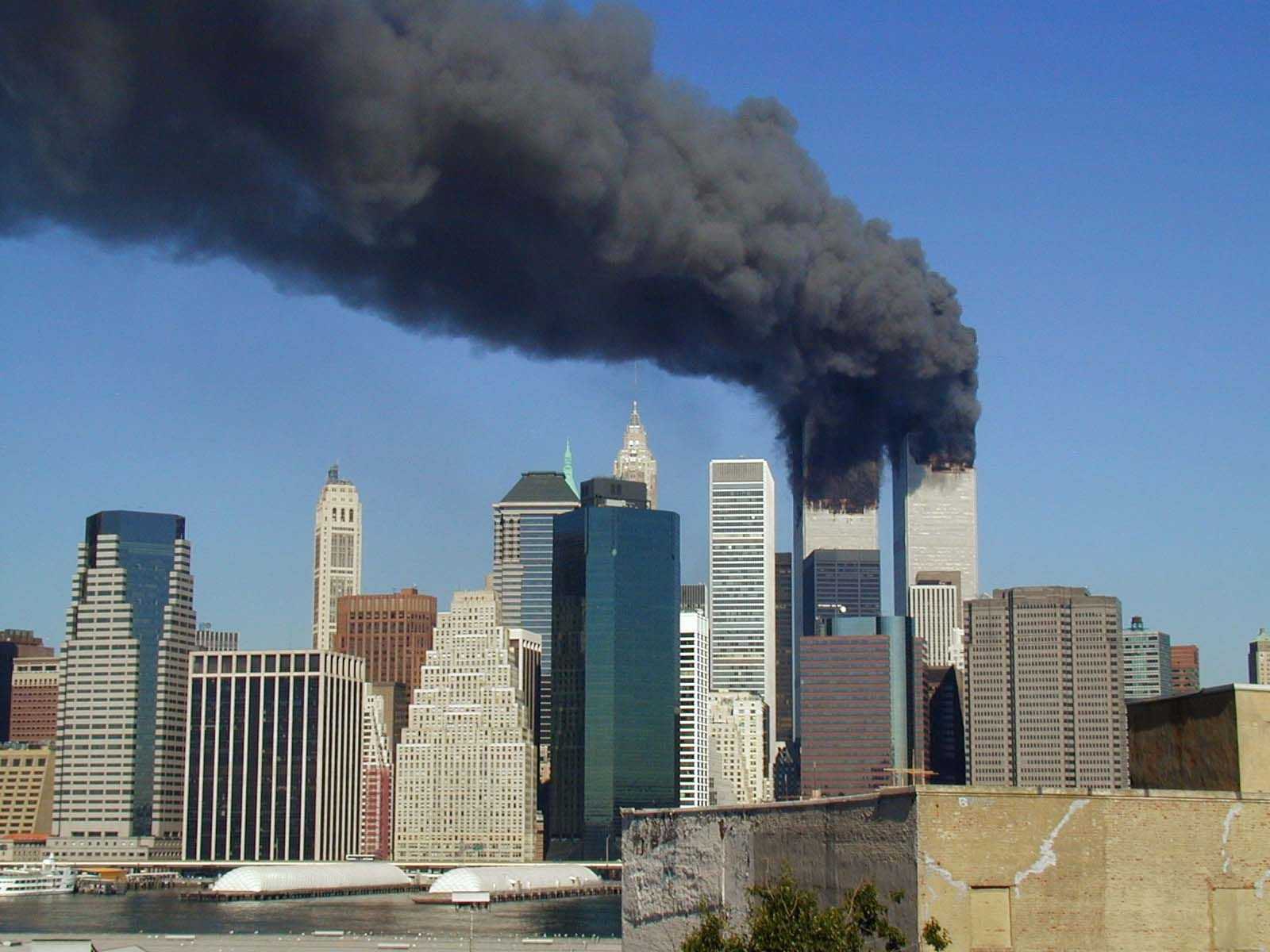Skyline of Manhatten with both towers of the World Trade Center burning shortly before their collapse