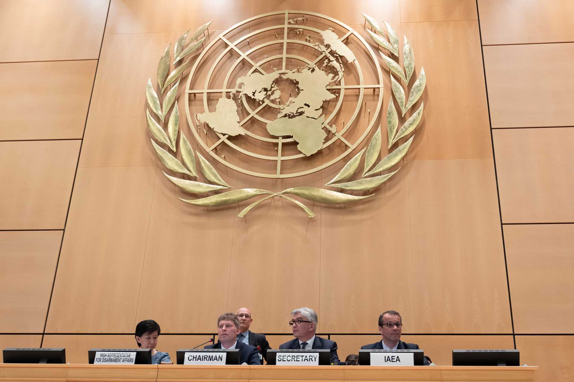 The High Representative for Disarmament Affairs, Chairman, Secretary and IAEA representative sit at a table in front of the UN Logo.