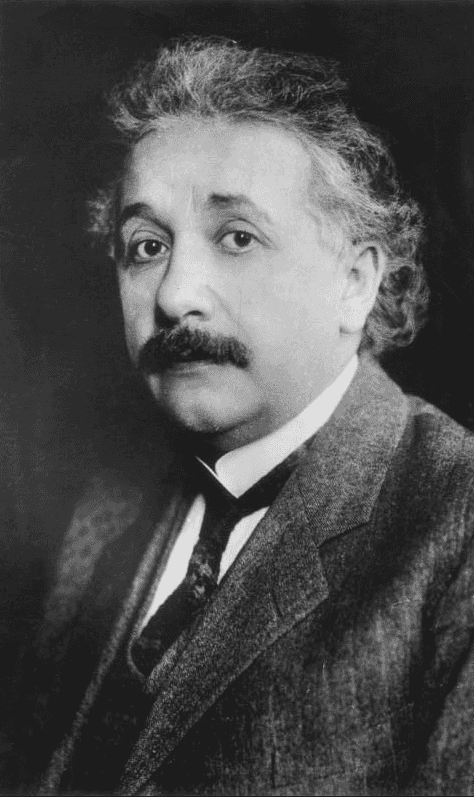 Black and white portrait photograph of Albert Einstein with his characteristic curly gray hair and mustache, wearing a three-piece suit, appearing to be from the early 20th century.