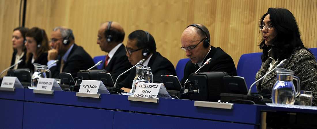 Photo of the IAEA forum on experiences with the creation of a nuclear-weapon-free zone in the Middle East. The photo shows various delegates sitting next to each other at the table. In the foreground is Ms. Gioconda Ubeda Rivera