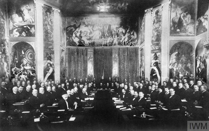 A historic photograph showing a group of elderly white men seated in a conference room, all facing the camera, dressed formally.