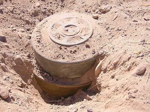 Landmine stuck in dirt.